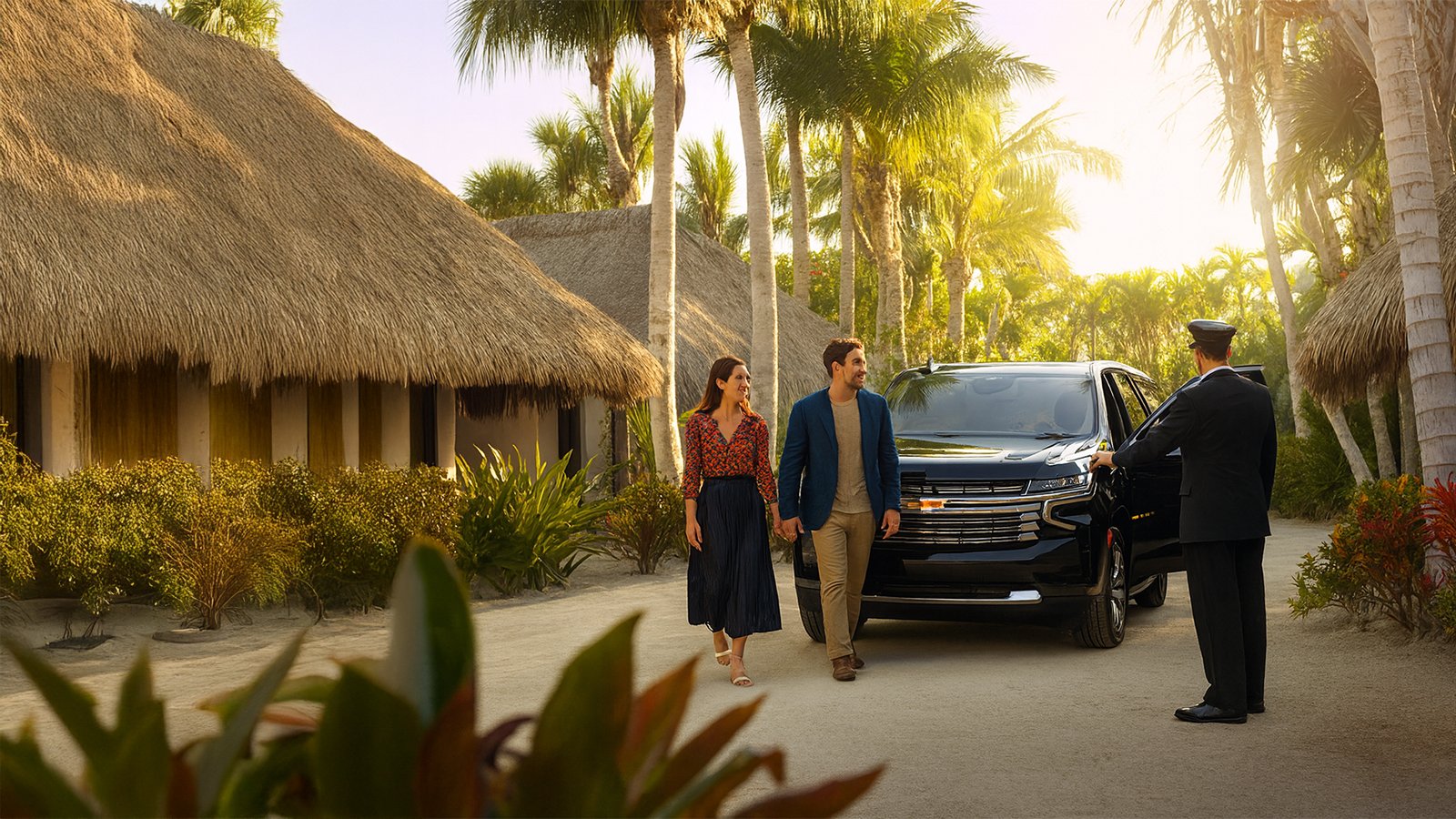 Elegant couple walking from black SUV with chauffeur at tropical resort